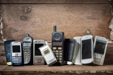 Old and obsolete mobile phone or cell phones on space of old woo